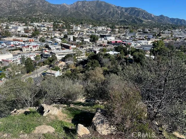 an aerial view of a houses with a lush green hillside
