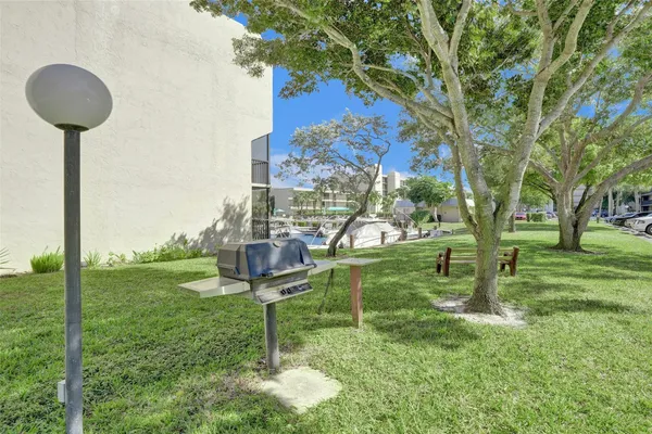 a view of a big yard with potted plants and large trees