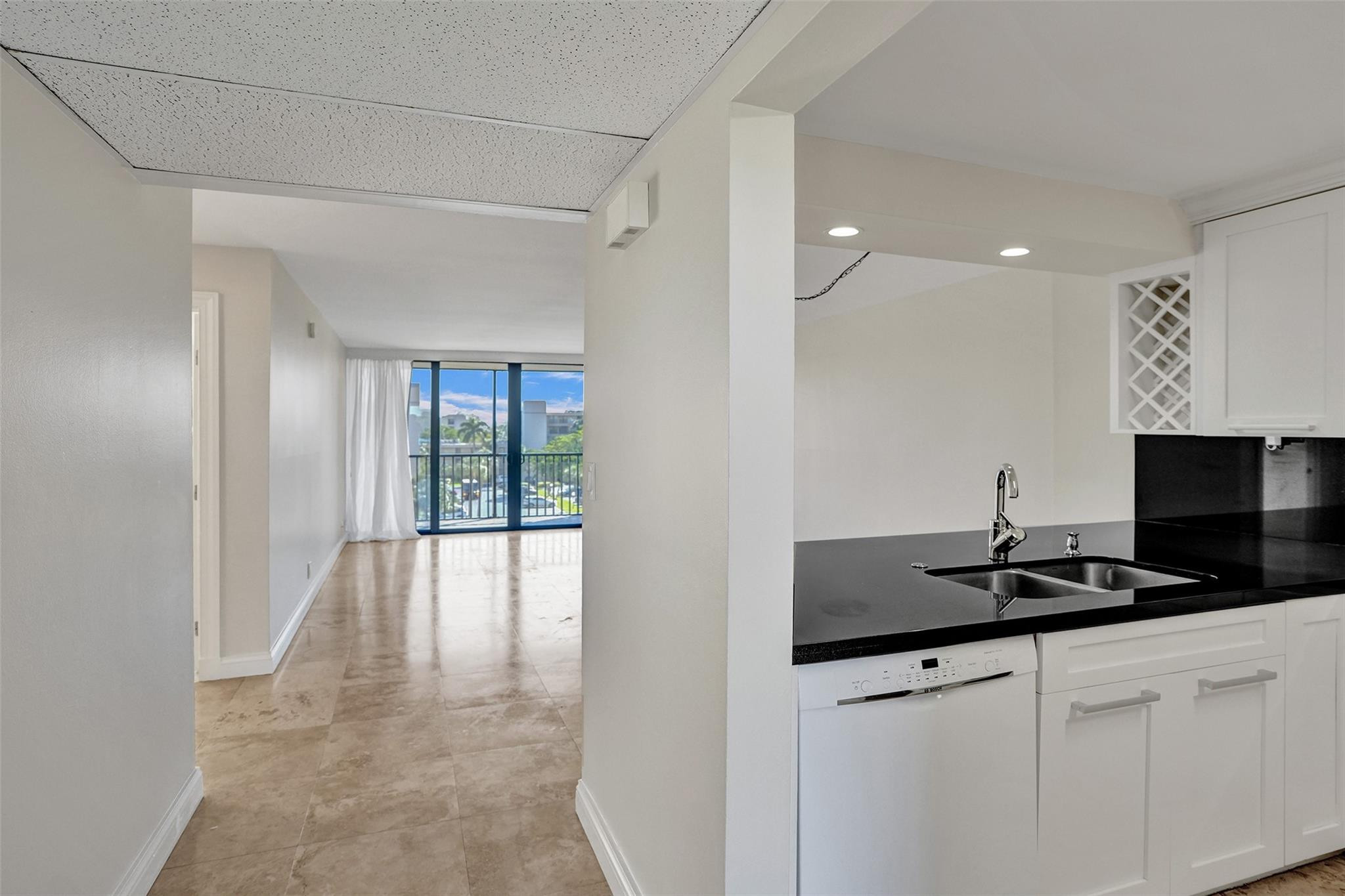 4 Royal Palm Way, Unit 503 Boca Raton, FL 33432 - Photo 6 of 36 a kitchen with granite countertop a sink and white cabinets