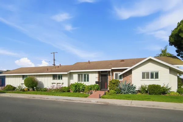 a front view of a house with a yard and potted plants
