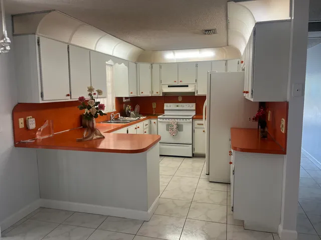 a kitchen with stainless steel appliances granite countertop a sink a stove and a refrigerator