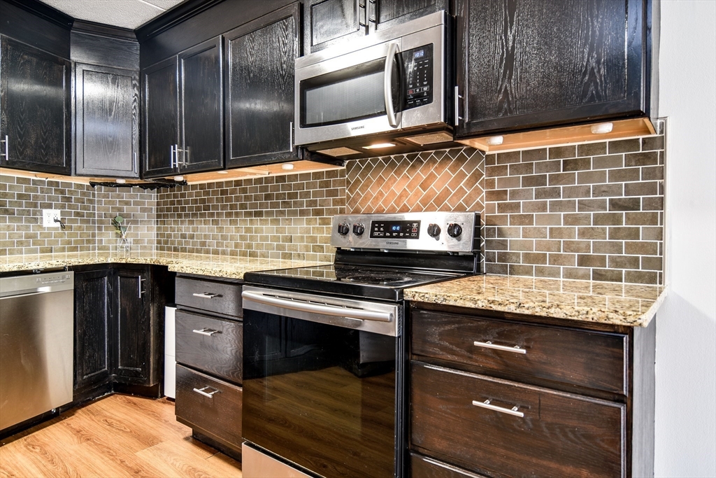 147 Turner Road, Unit 106 Holliston, MA 01746 - Photo 3 of 16 a kitchen with stainless steel appliances wooden cabinets and a sink