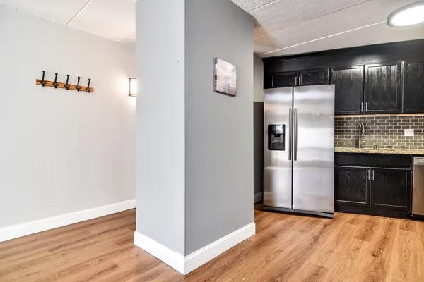 a view of an empty room with kitchen and a window