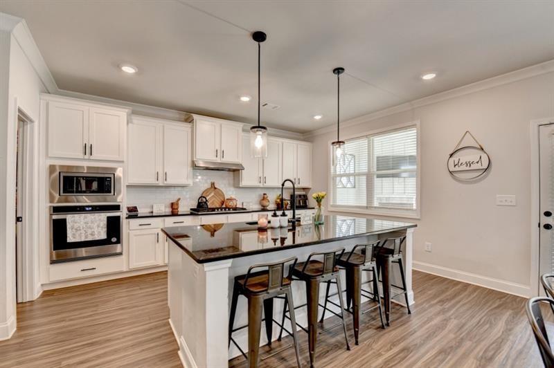 148 Logan Pass Drive Loganville, GA 30052 - Photo 28 of 103 a kitchen with stainless steel appliances granite countertop a stove top oven a sink refrigerator and cabinets