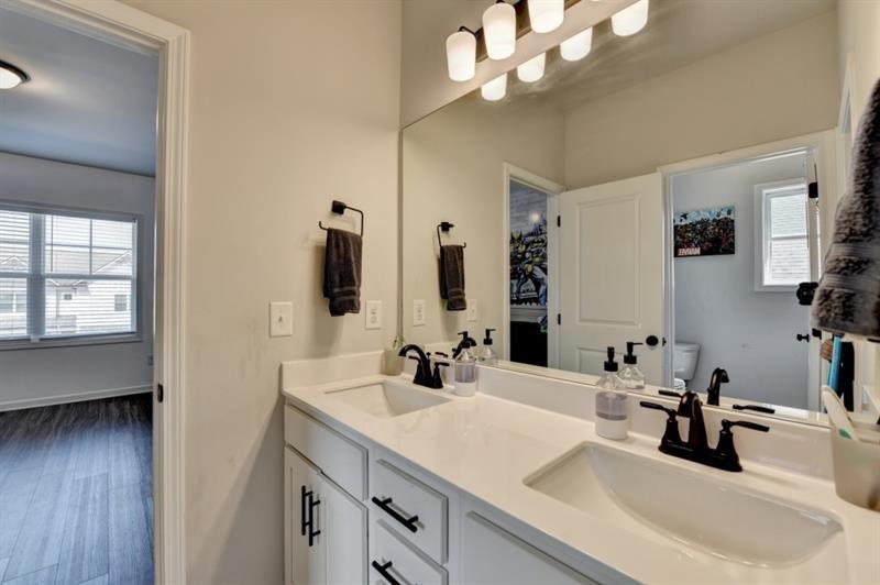 148 Logan Pass Drive Loganville, GA 30052 - Photo 61 of 103 a bathroom with double vanity sinks a vanity and a large mirror