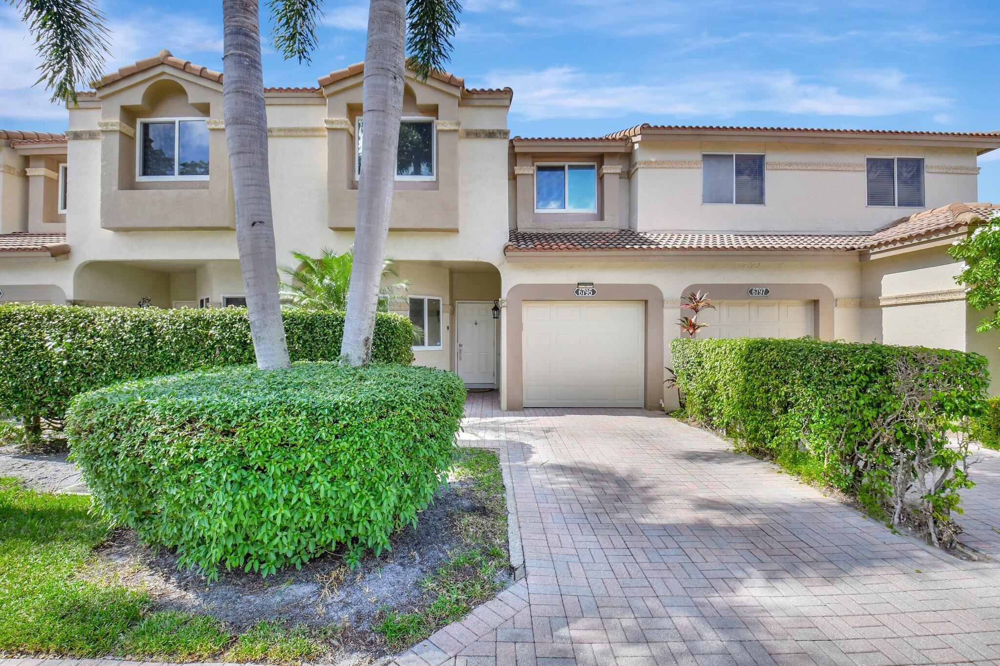 6795 Via Regina Boca Raton, FL 33433 - Photo 2 of 83 a front view of a house with a garden