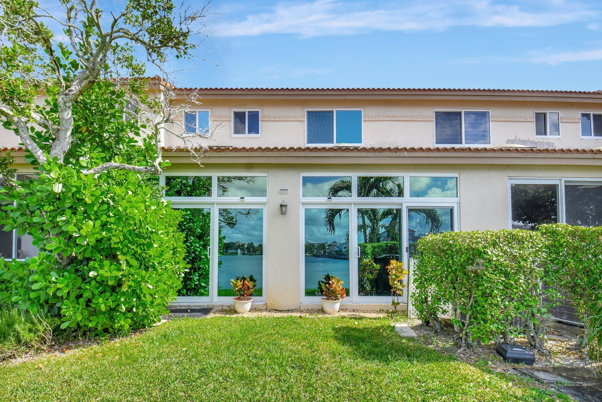6795 Via Regina Boca Raton, FL 33433 - Photo 26 of 83 a front view of a house with a yard and potted plants