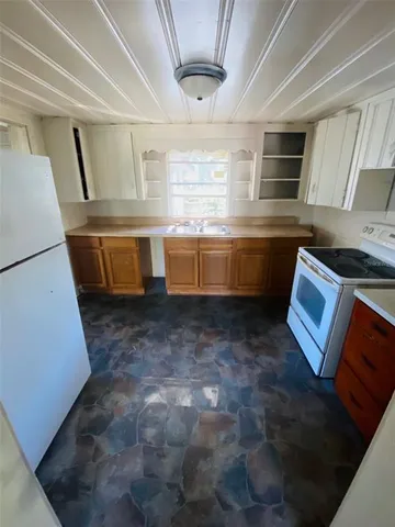 a kitchen with blue cabinets and white appliances