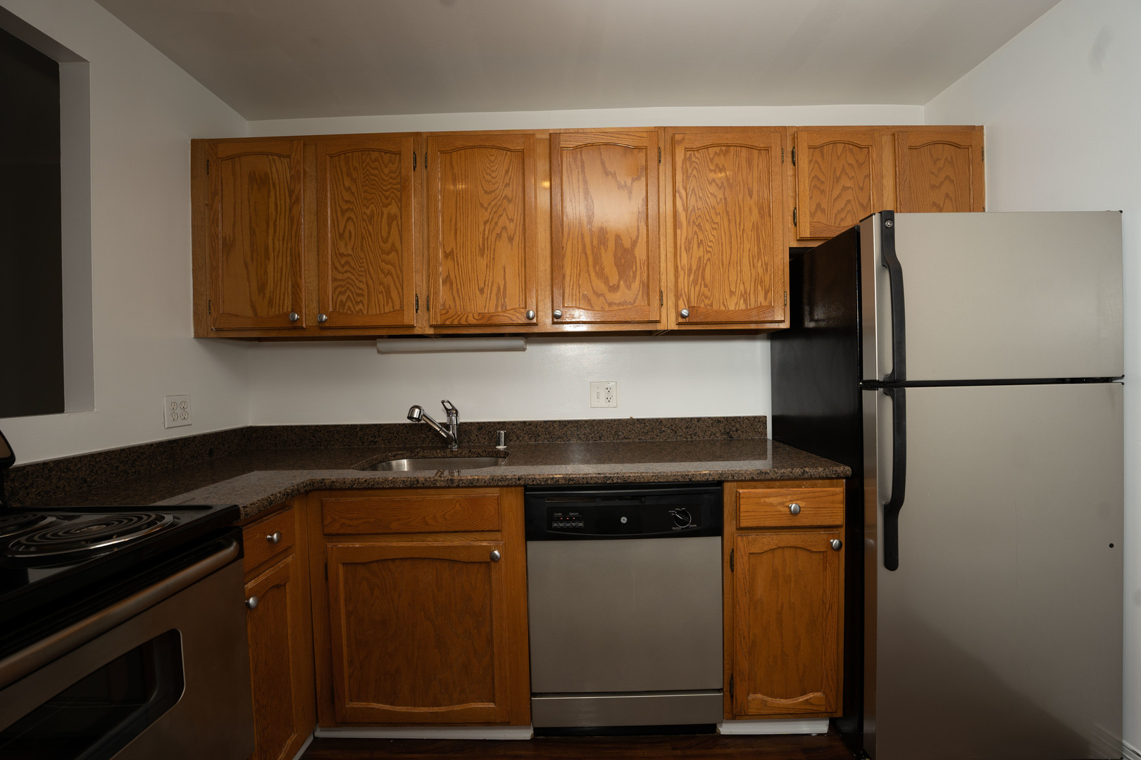 100 West Chestnut Street, Unit 2505 Chicago, IL 60610 - Photo 9 of 13 a kitchen with granite countertop cabinets stainless steel appliances and wooden cabinets