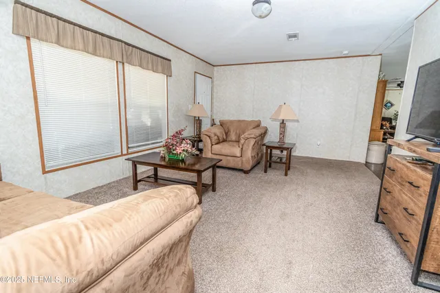 a kitchen with stainless steel appliances granite countertop a refrigerator a stove a sink dishwasher and a dining table with wooden floor