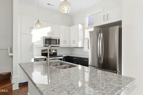 a view of a kitchen with furniture and wooden floor