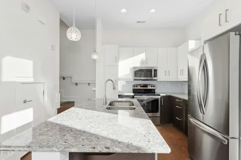 a kitchen with stainless steel appliances granite countertop a sink refrigerator and microwave