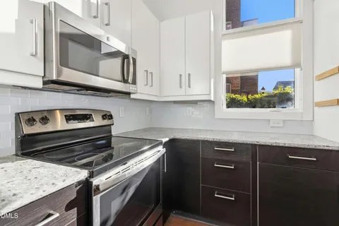 a kitchen with stainless steel appliances granite countertop a refrigerator stove microwave and sink