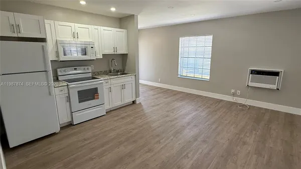 a kitchen with granite countertop white cabinets and stainless steel appliances