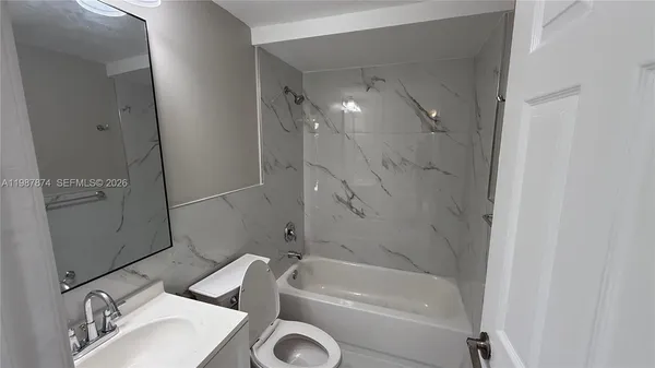a bathroom with a tub sink and mirror