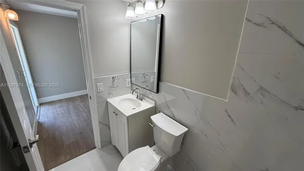 a bathroom with a sink toilet and mirror