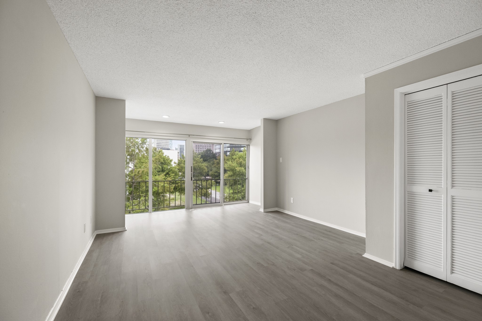 5050 Ambassador Way, Unit 316 Houston, TX 77056 - Photo 2 of 11 a view of an empty room with wooden floor and a window