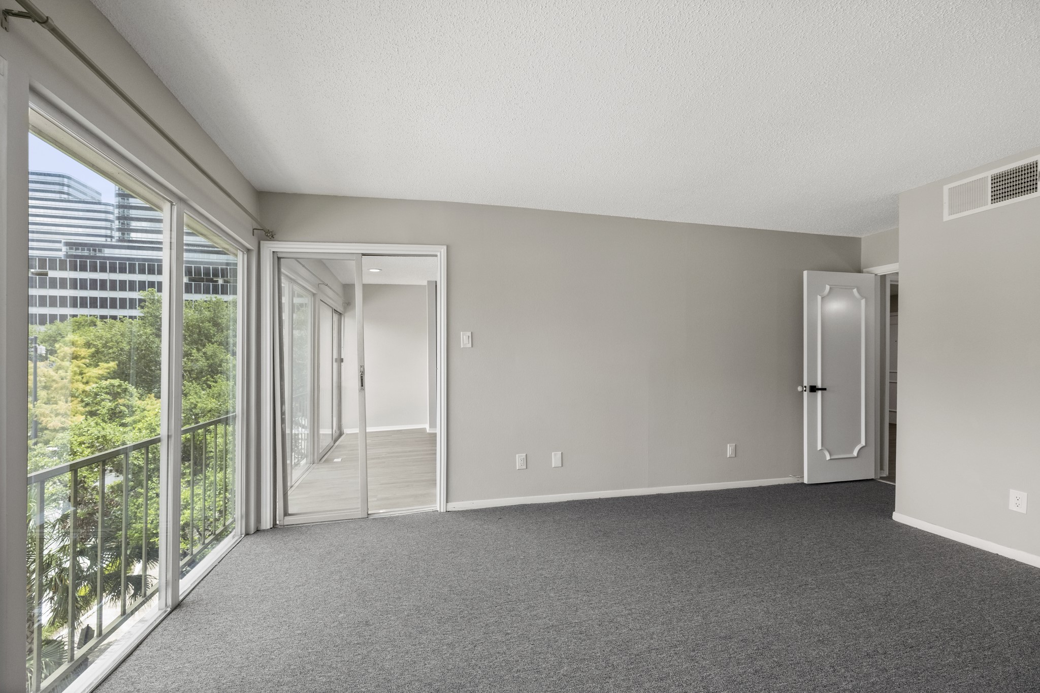 5050 Ambassador Way, Unit 316 Houston, TX 77056 - Photo 6 of 11 a view of an empty room with wooden floor and windows