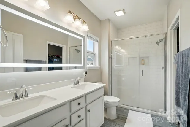 a bathroom with a sink a toilet and shower