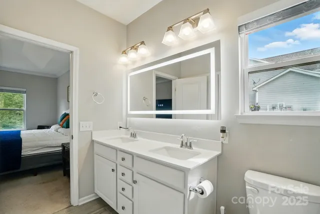 a en suite bathroom with a double vanity sink and a mirror