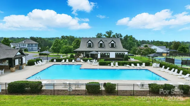 an aerial view of a tennis ground and a cars park side of the road