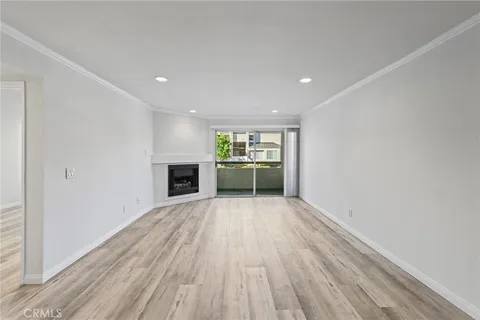 a view of an empty room with a fireplace and a window