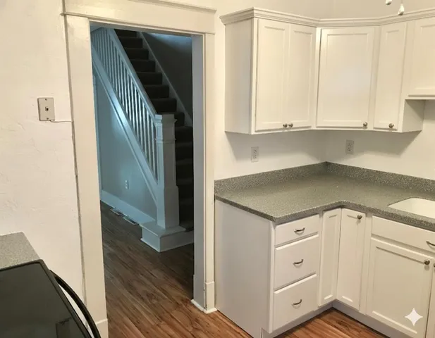 a view of a kitchen with white cabinets and a sink