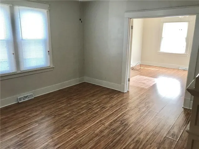 a view of a hallway with wooden floor and staircase