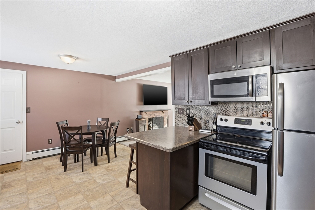153 Summer Street Maynard, MA 01754 - Photo 11 of 26 a kitchen with stainless steel appliances a stove microwave and cabinets