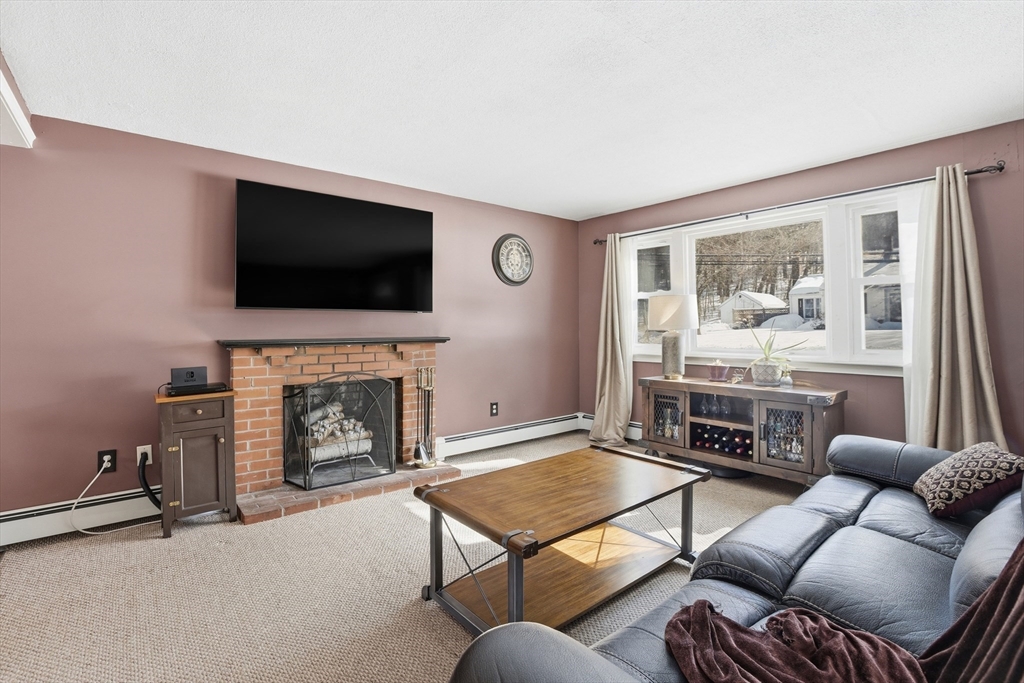 153 Summer Street Maynard, MA 01754 - Photo 5 of 26 a living room with furniture a fireplace and a flat screen tv