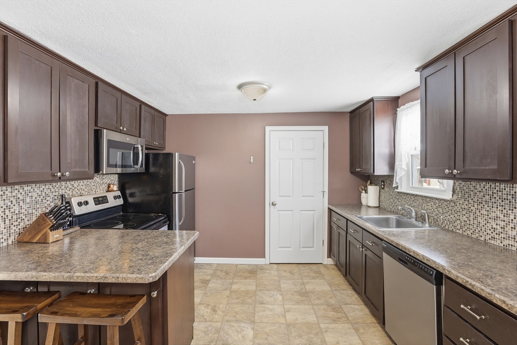 153 Summer Street Maynard, MA 01754 - Photo 9 of 26 a kitchen with stainless steel appliances granite countertop a sink stove and refrigerator