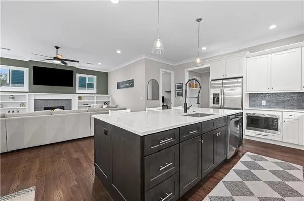 a large kitchen with kitchen island a sink stainless steel appliances and cabinets