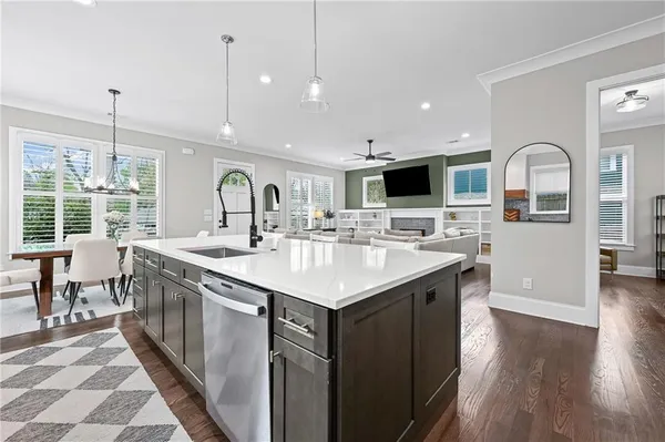 a kitchen with stainless steel appliances granite countertop a sink a stove top oven a counter space and living room view
