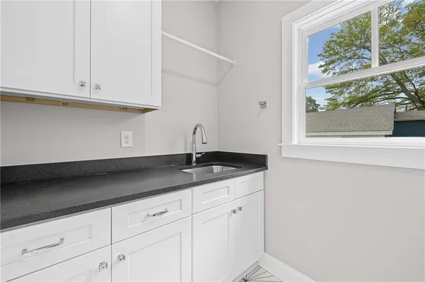 a kitchen with granite countertop white cabinets and a sink