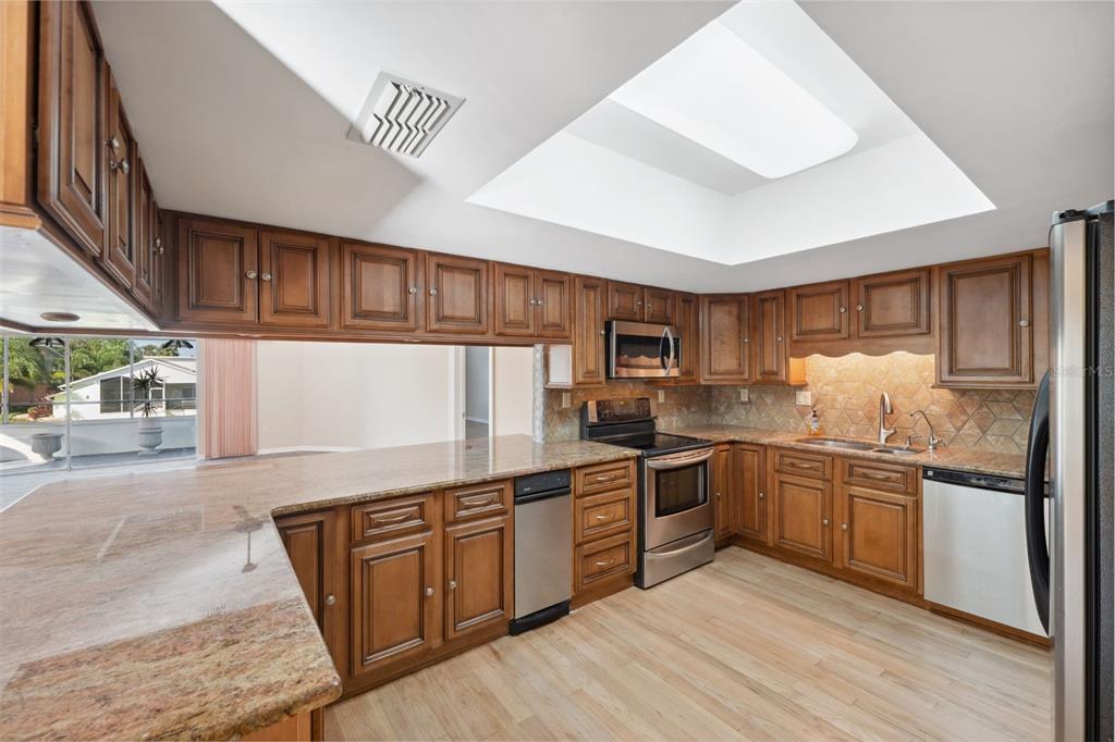 6225 Bayside Drive New Port Richey, FL 34652 - Photo 14 of 84 a kitchen with stainless steel appliances granite countertop a stove and cabinets