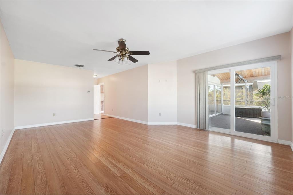 6225 Bayside Drive New Port Richey, FL 34652 - Photo 22 of 84 a view of empty room with wooden floor and fan