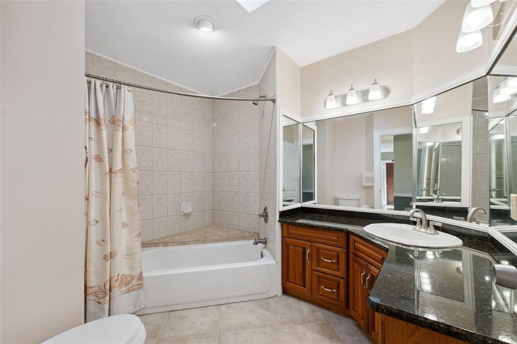 6225 Bayside Drive New Port Richey, FL 34652 - Photo 29 of 84 a bathroom with a double vanity sink a mirror a bathtub and shower