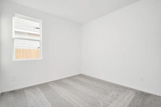 a view of a small space with wooden floor and a window