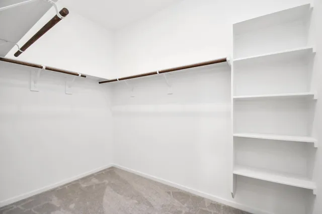 a view of walk in closet with empty racks