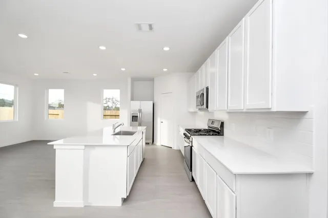 a kitchen with stainless steel appliances a sink stove and cabinets