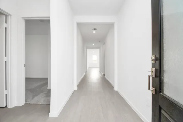 a view of a hallway with wooden floor