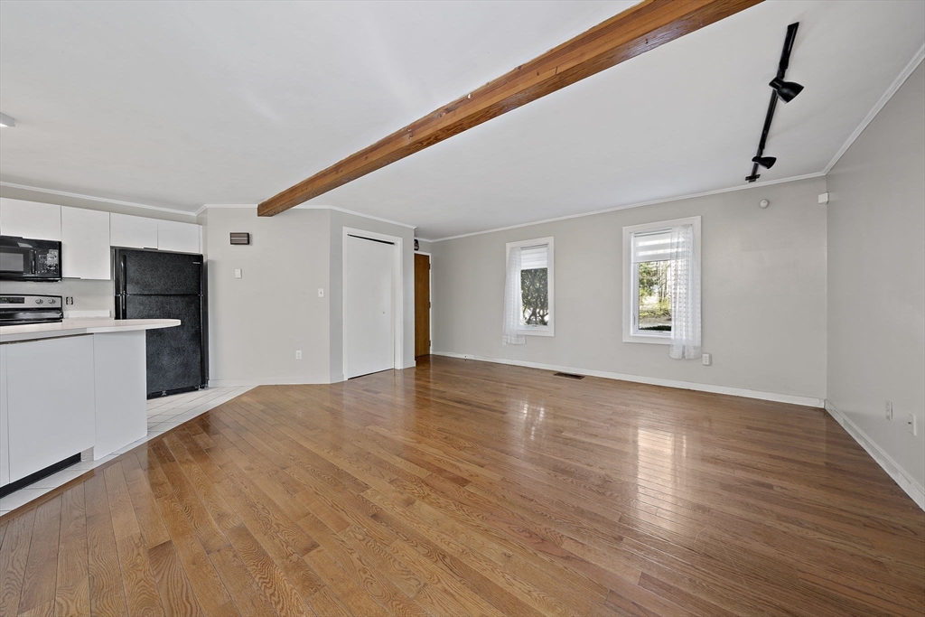 20 Jasper Lane, Unit 20 Randolph, MA 02368 - Photo 5 of 13 a view of empty room with wooden floor and kitchen view