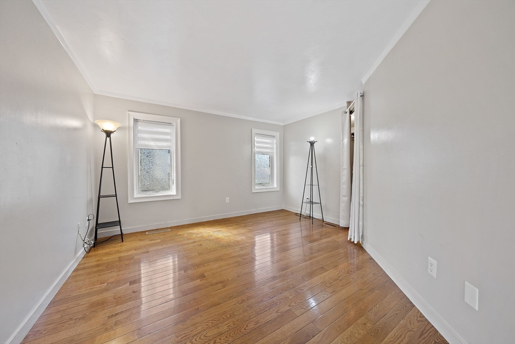 20 Jasper Lane, Unit 20 Randolph, MA 02368 - Photo 8 of 13 a view of an empty room with wooden floor and a window
