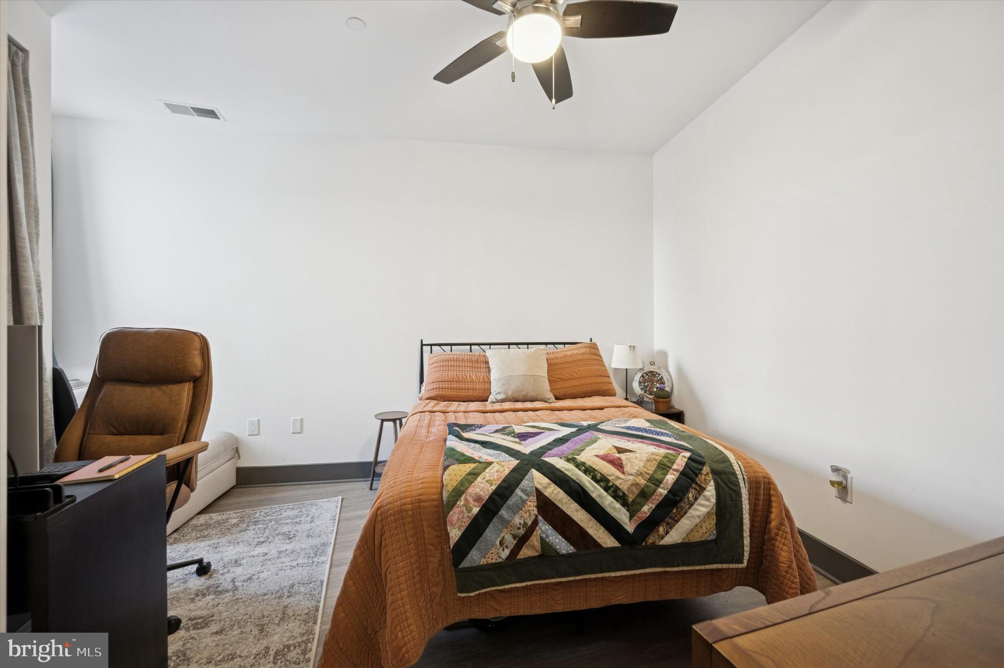 124-26 Levering Street, Unit 2A Philadelphia, PA 19127 - Photo 11 of 18 a bedroom with a bed and a chandelier