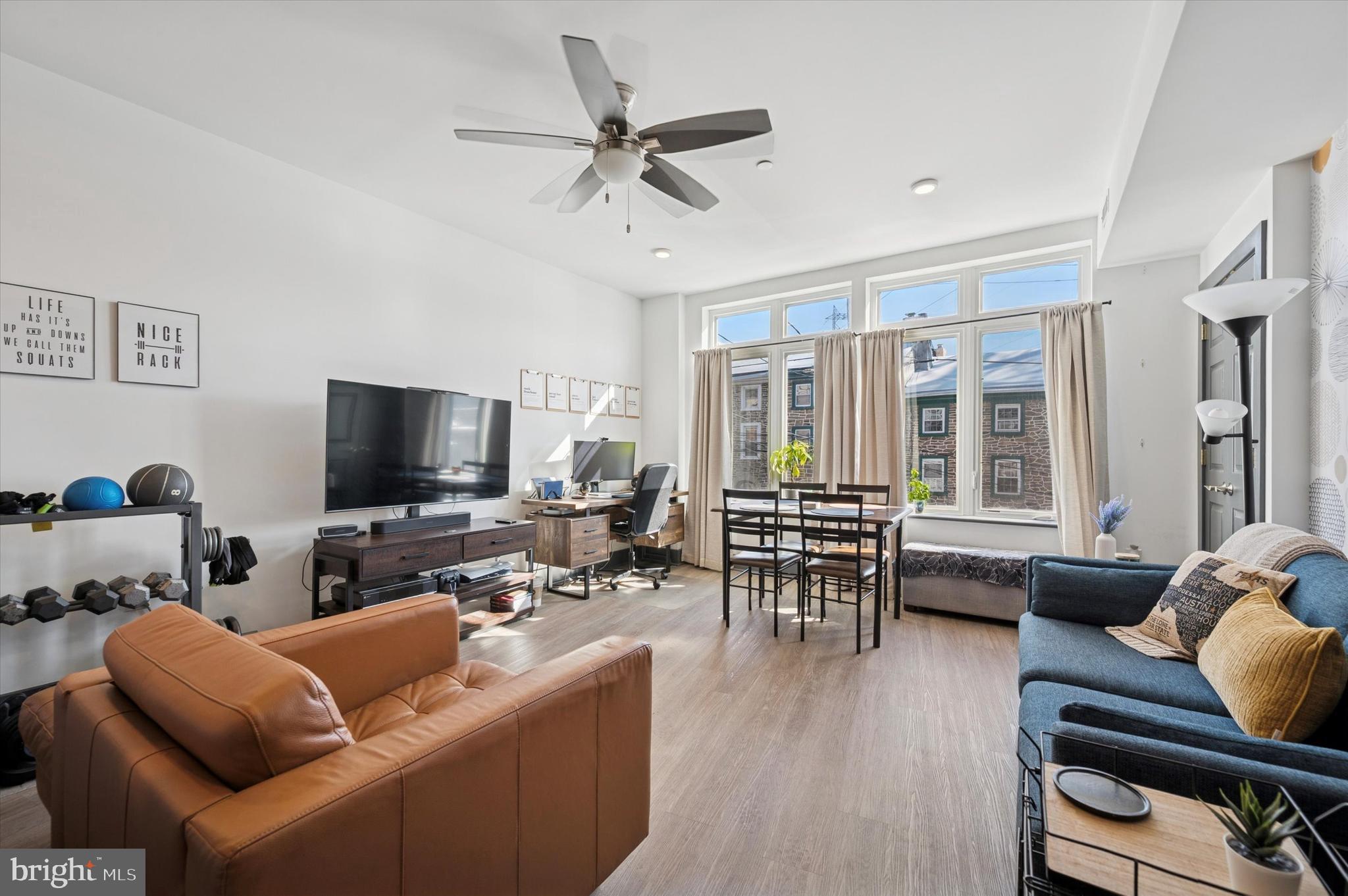 124-26 Levering Street, Unit 2A Philadelphia, PA 19127 - Photo 3 of 18 a living room with furniture and a flat screen tv with wooden floor