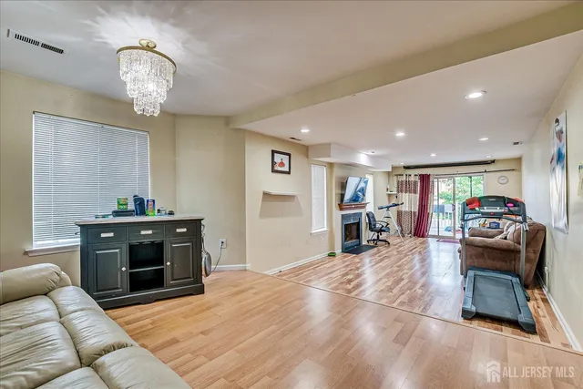 a living room with furniture a fireplace and a chandelier