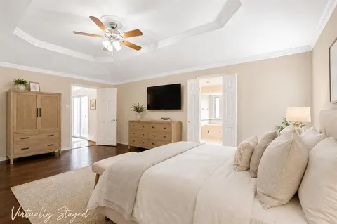 a bedroom with a large bed a flat tv screen and closet