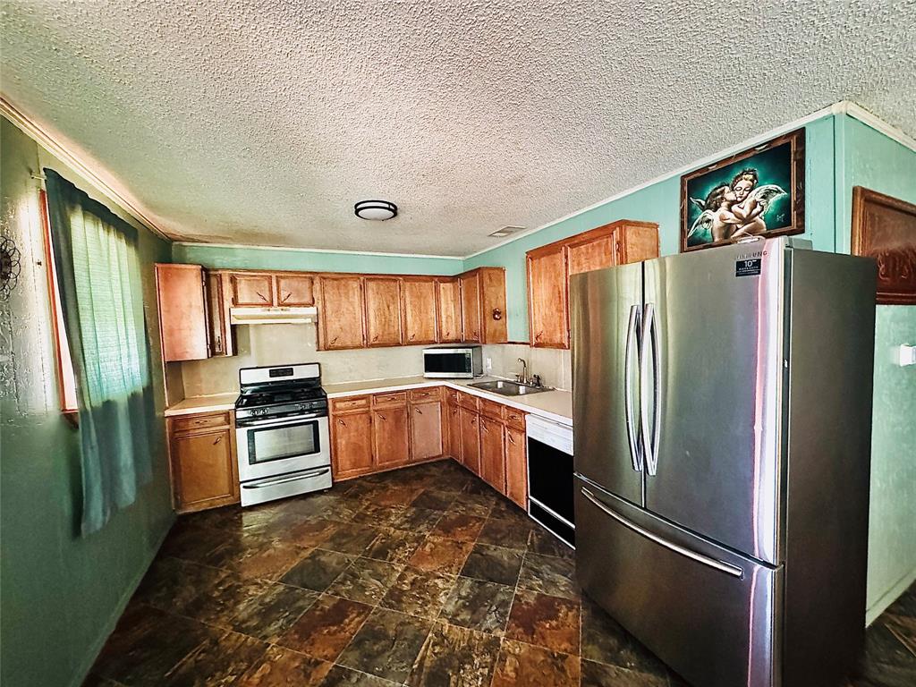 238 South 8th Street Jacksboro, TX 76458 - Photo 2 of 9 a kitchen with stainless steel appliances granite countertop a refrigerator stove and sink
