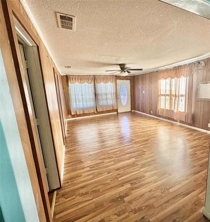 238 South 8th Street Jacksboro, TX 76458 - Photo 4 of 9 a view of an empty room with wooden floor and a window