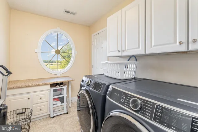 an empty room with windows and chandelier fan